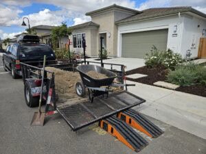 Lawn mowing trailer with equipment parked in front of a new residential home in Tracy, CA.